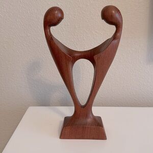 Carved wooden sculpture. Lovers forming a heart embrace. Wedding or anniversary.